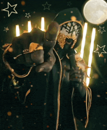 a man with a mask on his face is holding a microphone and pointing