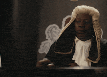 a man in a wig is holding a gavel in front of a flag