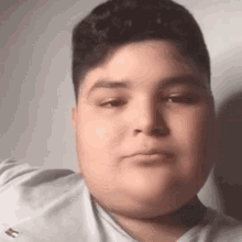 a close up of a young boy 's face with a very large belly .