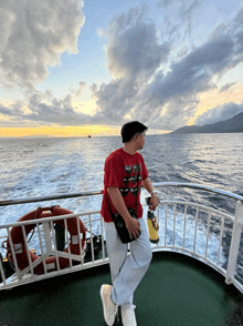 a man on a boat wearing a red t-shirt that says ' i love you ' on it