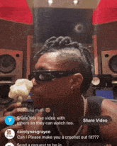 a woman wearing sunglasses is holding a white rose in front of speakers and a share video button