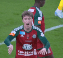 a soccer player wearing a red and green jersey with the number 10 on the back