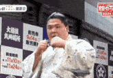 a man in a kimono stands in front of a sign with chinese writing