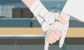 a person with bandages on their wrists holds another person 's hand