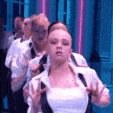 a group of people are standing in a line and dancing .