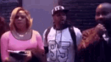 a group of people are standing next to each other in a room .