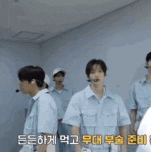 a group of men are standing in a room with korean writing on the bottom