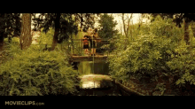 a movie clip of a family standing on a bridge over a river