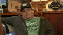 a man is sitting in front of a sign that says dragon and things