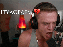 a man wearing headphones has a broken heart on his head and the words " ityaofafm " below him