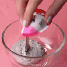 a person is pouring a pink liquid into a glass bowl