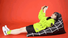 a girl is laying on a bean bag chair holding a game controller