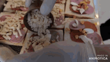 a person is adding cheese to a sandwich with the words made in animatica on the bottom right