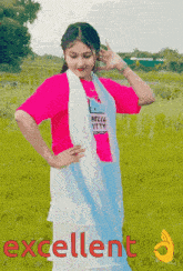 a girl wearing a pink hello kitty shirt is standing in a field