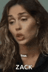 a woman is making a funny face while talking to zack .