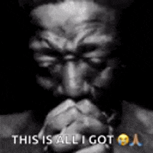 a man with a beard is praying with his hands folded in prayer .