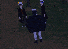 a man in a black robe is standing next to a man in a black cape with the number 187 on it