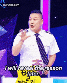 a man in a tie says i will reveal the reason later