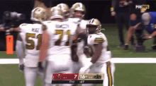 a group of football players on a field with the number 51 on their uniform