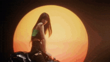 a woman is sitting on a motorcycle in front of a large orange sun .