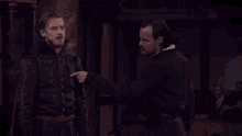 a man with a beard is laughing while another man looks at him