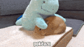 a stuffed animal laying on top of another stuffed animal that says pokeazu