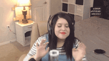 a woman wearing headphones is sitting in front of a table with a sign that says " lucky " on it