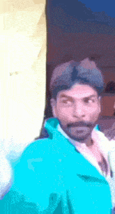 a man with a blue jacket on looks at the camera
