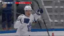 a hockey player in a toronto maple leafs uniform celebrates his goal