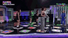 a group of people are dancing on a dance floor in front of a sign that says rainbow on it
