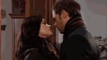 a man and woman kissing in front of a mirror