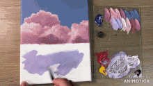 a person is painting a cloudy sky with purple and pink paint