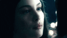 a close up of a woman 's face in a dark room looking at the camera .