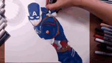 a person is drawing a picture of captain america