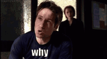 a man wearing a black shirt that says " why "