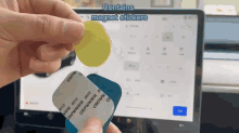 a person is holding a package of magnet stickers in front of a screen