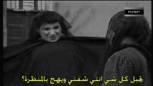 a black and white photo of two women with arabic writing on them