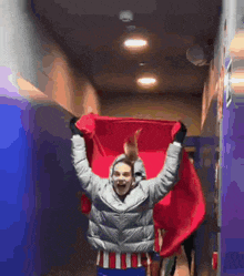 a man in a grey jacket is holding a red flag in his hands