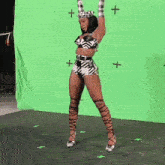 a woman dancing in front of a green screen