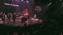 a stage with a sign that says worthy is your name on it