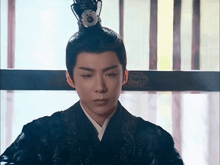 a man with a crown on his head looks down at something