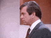 a man in a suit and tie is looking to his left .