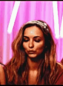 a woman wearing a headband is making a funny face .