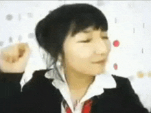 a woman in a suit and tie is making a funny face while wearing headphones .