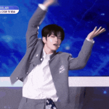 a man in a suit and white shirt is dancing in front of a blue screen that says solar
