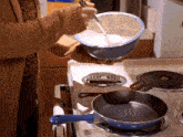 a woman is pouring something into a bowl on a stove