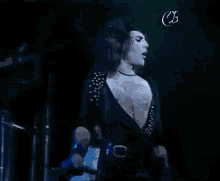 a man is standing on a stage holding a microphone and singing into it .