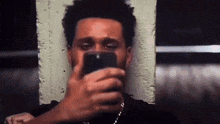 a man is taking a selfie with a cell phone .