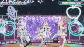 three anime girls are dancing on a stage in front of a sign that says ' 絶対 アイドル ' on it