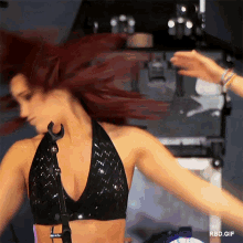a woman in a black top is dancing in front of a microphone with rbd.gif written on the bottom